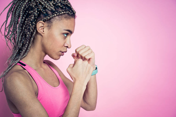 Beautiful girl doing exercises and sport. Posing on a pink colored background - Foto, Bild