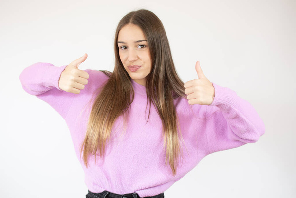 Teenager Mädchen isoliert auf weißem Hintergrund zeigt Siegeszeichen mit beiden Händen - Foto, Bild