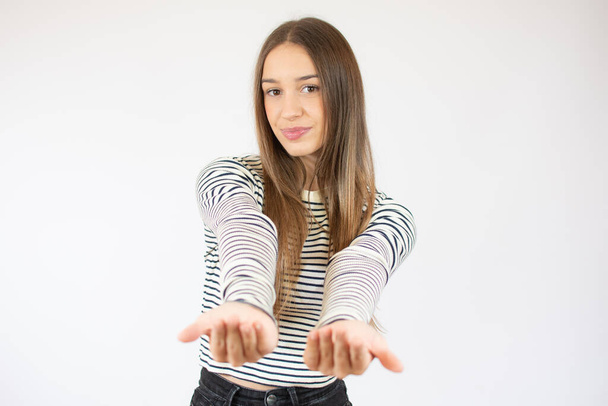 Happy girl in striped t-shirt gesturing beckoning isolated on a white background - Φωτογραφία, εικόνα
