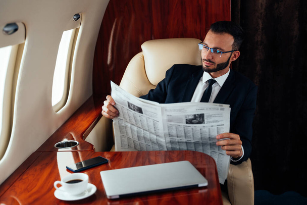 Businessman flying on his private jet. Concept about business, and transportation - Zdjęcie, obraz