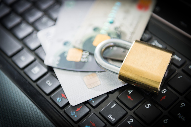 Padlock and credit cards on top of laptop - Photo, Image