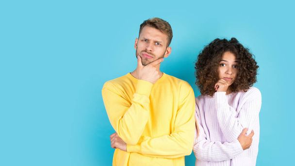Concept of good or bad solution. Panoramic view of thoughtful mixed race friends standing together on blue background with copy space. Minded man and contemplating woman looking at camera - Photo, Image
