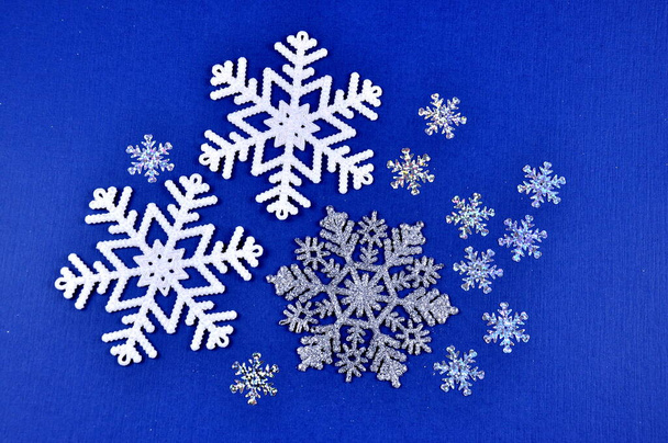 Christmas toys, balloons and decorative snowflakes on a blue background. - Φωτογραφία, εικόνα