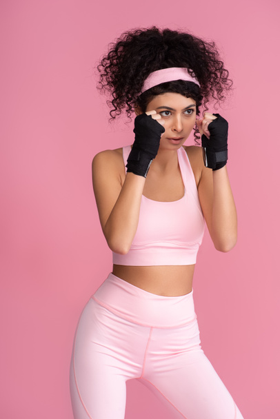 strong young woman in sportswear with bondage on hands isolated on pink - Zdjęcie, obraz
