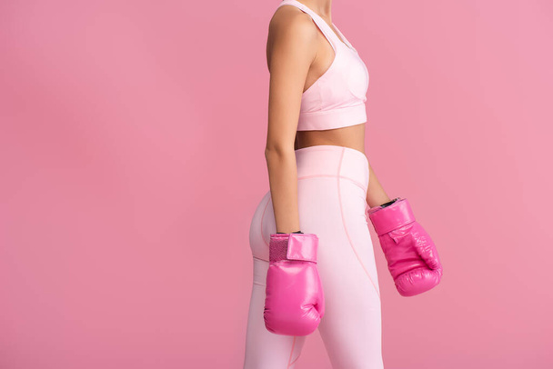 cropped view of young sportswoman in boxing gloves standing isolated on pink  - Fotó, kép