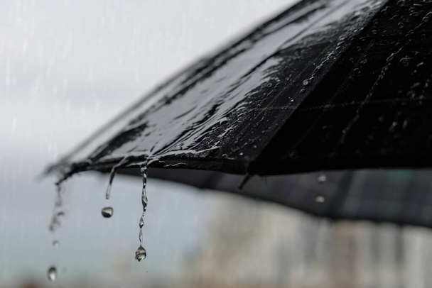 Dešťové kapky tekoucí z deštníku, koncepce deštivého počasí, selektivní zaměření - Fotografie, Obrázek