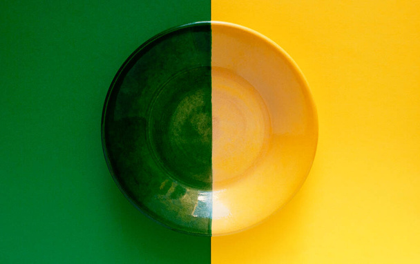 A green yellow plate on a green yellow background. Two main colors - yellow and green. - Photo, Image
