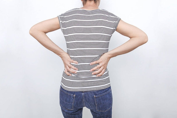 The woman is touching her aching waist. Low back pain concept. Health concept.  - Photo, Image
