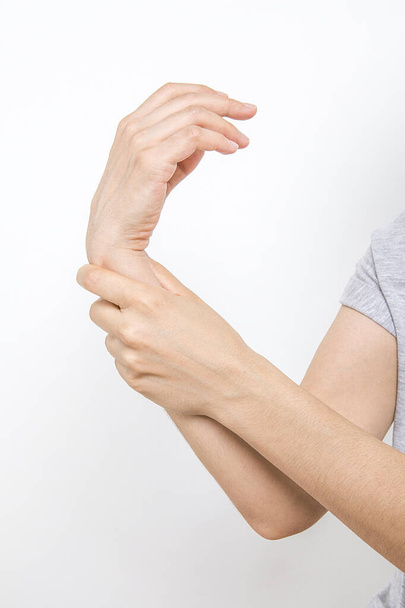  Женщина держит запястье. Концепция боли. Женщина держит руку за пятна от боли в запястье. Office Syndrome.Wrist боли.  - Фото, изображение