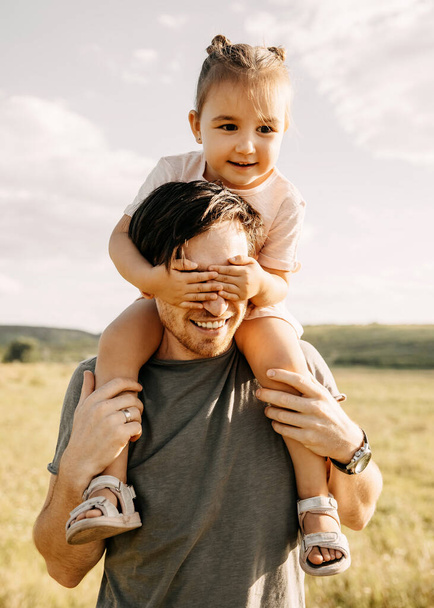 otec a dcera tráví čas spolu a piggybacking na přírodě - Fotografie, Obrázek