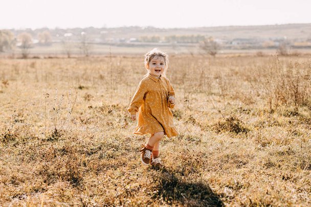 entzückendes kleines Mädchen in stilvollem Kleid über die Natur - Foto, Bild