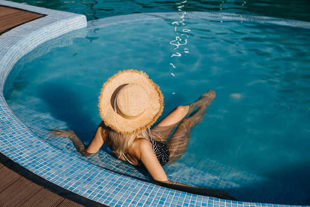 красива молода блондинка розслабляється в басейні
 - Фото, зображення