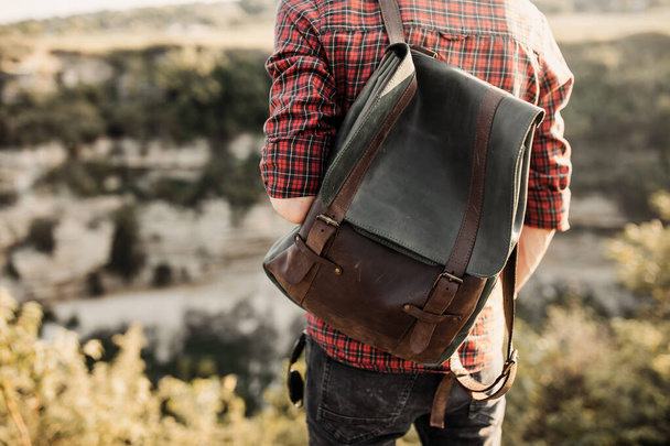 portrait of handsome young man with leather backpack on nature - Fotoğraf, Görsel