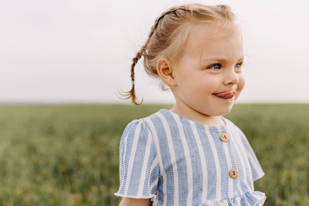 портрет чарівної маленької дівчинки в зеленому полі
 - Фото, зображення