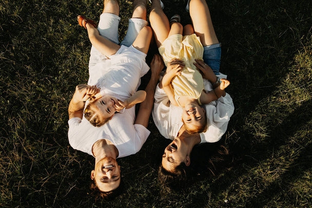красива молода сім'я з двома дочками проводить час разом на природі
 - Фото, зображення