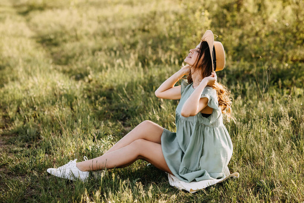 bela jovem no vestido e chapéu de palha no jardim da maçã no pôr do sol - Foto, Imagem