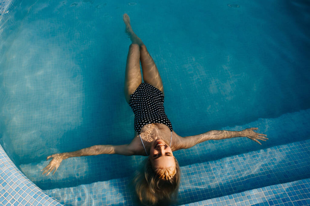 hermosa mujer rubia joven relajándose en la piscina - Foto, Imagen