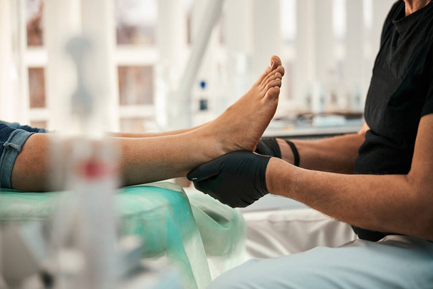 Nahaufnahme von kompetentem Arzt bei Fußmassage - Foto, Bild
