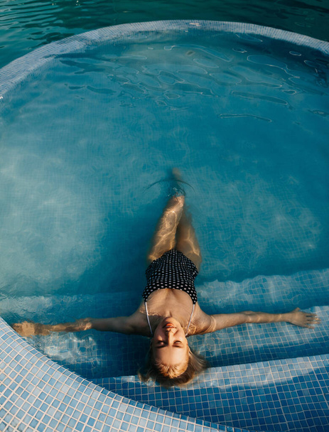 beautiful young blonde woman relaxing in swimming pool - Valokuva, kuva