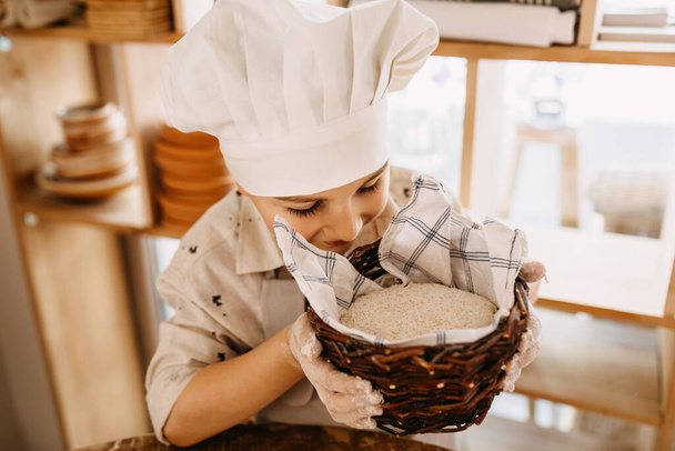 крупним планом знімок чарівного маленького хлопчика, який готує тісто для випічки
 - Фото, зображення
