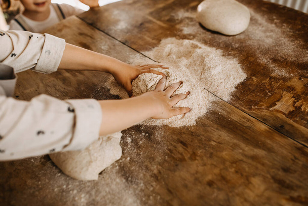 close-up shot of adorable little kid preparing dough for pastry - Photo, Image