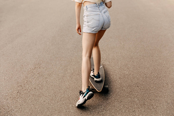 cropped shot of woman with long board on street - Photo, Image