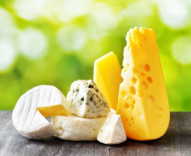 Different types of cheese on nature background - Φωτογραφία, εικόνα