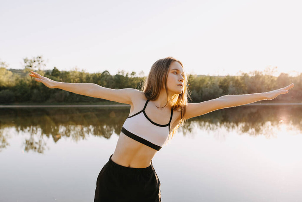 Красивая молодая женщина практикует йогу на открытом воздухе
 - Фото, изображение