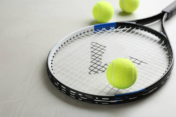 Tennis racket and balls on grey table. Sports equipment - Foto, Imagen