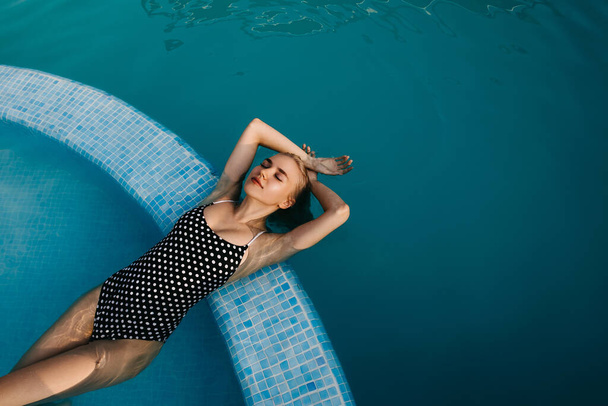 красивая молодая блондинка расслабляется в бассейне - Фото, изображение