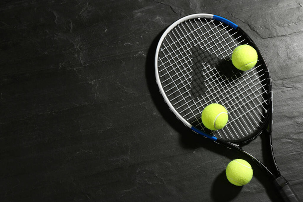 Tennis racket and balls on black table, flat lay. Sports equipment - Foto, afbeelding