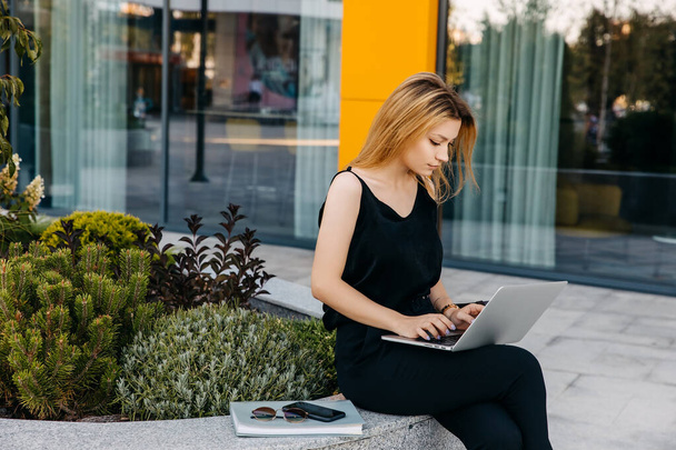 beautiful young businesswoman working with laptop on city street - Foto, Imagem