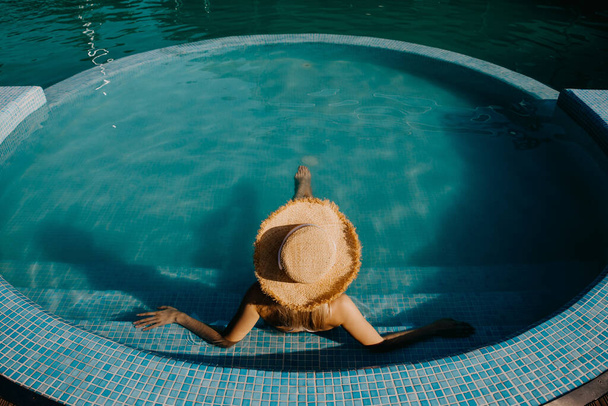 beautiful young blonde woman relaxing in swimming pool - Zdjęcie, obraz