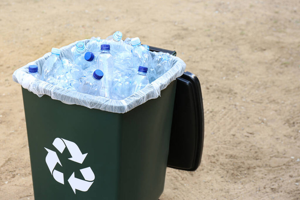 Many used plastic bottles in trash bin outdoors. Recycling problem - Фото, зображення