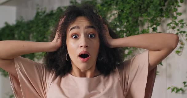 Portrait of young successful surprised afro american curly girl black woman feeling amazement wonder delight holding her head with her hands covering her mouth with her palms says wow, triumph victory - Filmagem, Vídeo