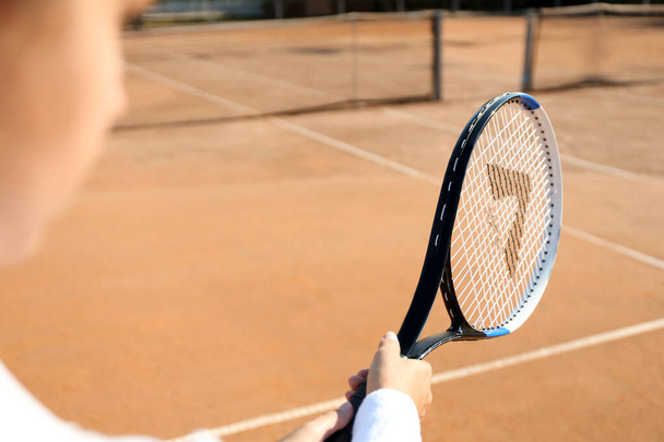 Sportswoman playing tennis at court on sunny day, closeup - Fotó, kép