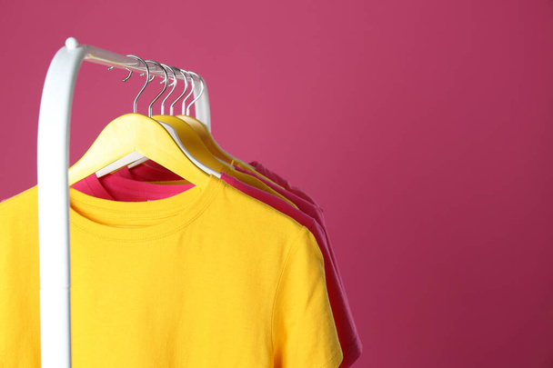 Rack with stylish children clothes on pink background, closeup. Space for text - Foto, immagini