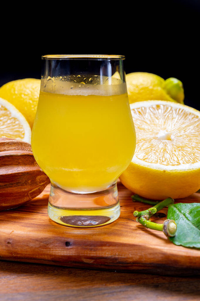 Sklenice studeného sladkého limoncello likéru z nové sklizně čerstvě zralých italských citronů, pobřeží Amalfi, Itálie - Fotografie, Obrázek