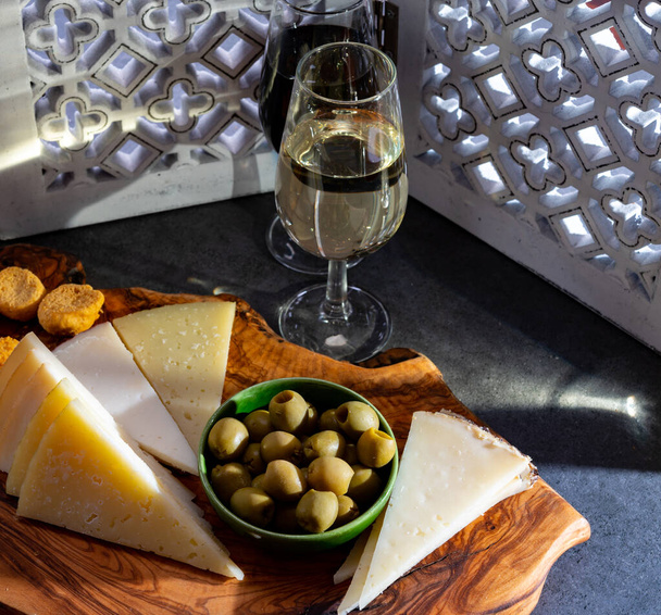 Γευσιγνωσία οχυρωμένου ανδαλουσιανού ξηρού φίνου και γλυκού κρασιού σέρι με παραδοσιακά τάπας Spanisch, πράσινες ελιές, κατσικίσιο και πρόβειο τυρί manchego - Φωτογραφία, εικόνα
