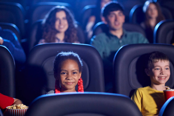 Niños multiraciales disfrutando de dibujos animados en la sala de cine. - Foto, Imagen