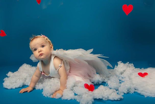 Μικρό χαριτωμένο κορίτσι άγγελοι σε μπλε φόντο για την ημέρα του Αγίου Βαλεντίνου - Φωτογραφία, εικόνα