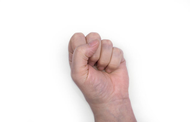 Γυναικείο χέρι σε λευκό. Σφιγμένη γροθιά - Φωτογραφία, εικόνα