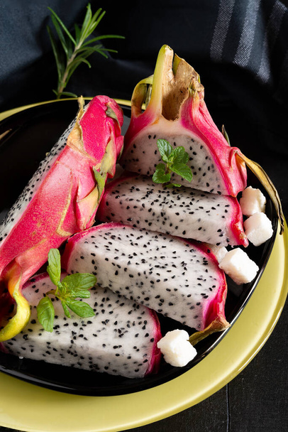 Fruta tropical pitaya vermelha fatiada com coco em cubos na mesa de madeira - Foto, Imagem