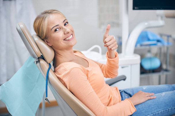 Joyeuse jeune femme se sentant bien chez le dentiste - Photo, image