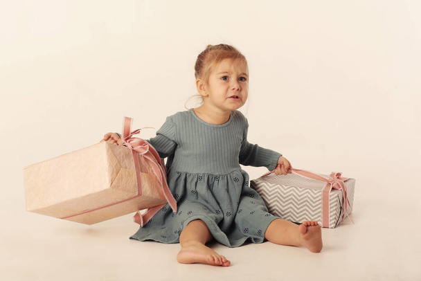 niedliche kleine blonde Baby-Mädchen in blauem Kleid mit Weihnachtsgeschenkbox Nahaufnahme Foto isoliert auf weiß - Foto, Bild