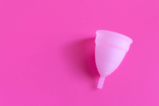 Puchar menstruacyjny na różowym tle. Alternatywny kobiecy produkt higieniczny w tym okresie. Koncepcja zdrowia kobiet. Przestrzeń kopiowania. - Zdjęcie, obraz