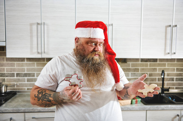 Несподівано з татуювальником у капелюсі Санта Клауса готують різдвяне печиво. - Фото, зображення