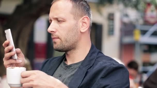 άνθρωπος γραπτών μηνυμάτων και πίνοντας καφέ - Πλάνα, βίντεο