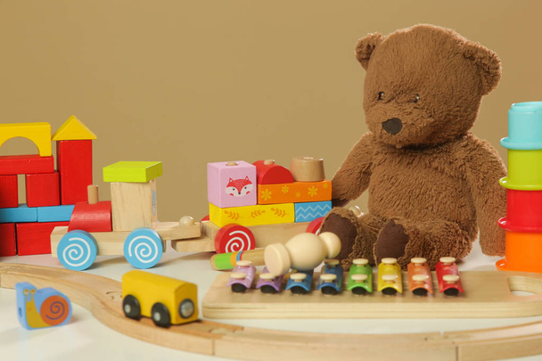 Jouets colorés pour enfants sur table, jouets en bois, plastique et peluche - Photo, image