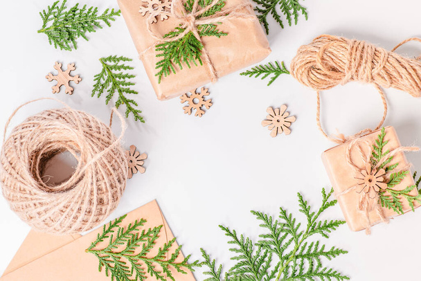 Weihnachtliches Arrangement aus Tannenzweigen, kleinen Holzfiguren und einem Geschenk. Weihnachtsgrußkarte, Banner. Kopierraum. - Foto, Bild